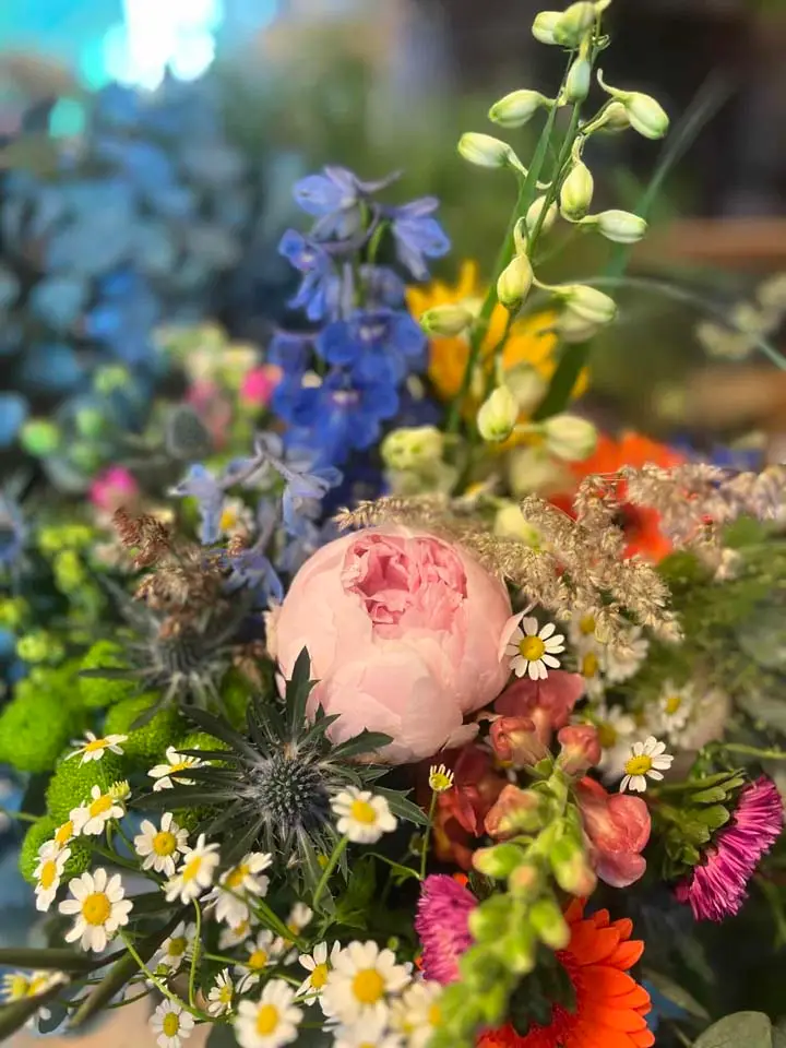 Farverig buket med pæon, ridderspore og margueritter