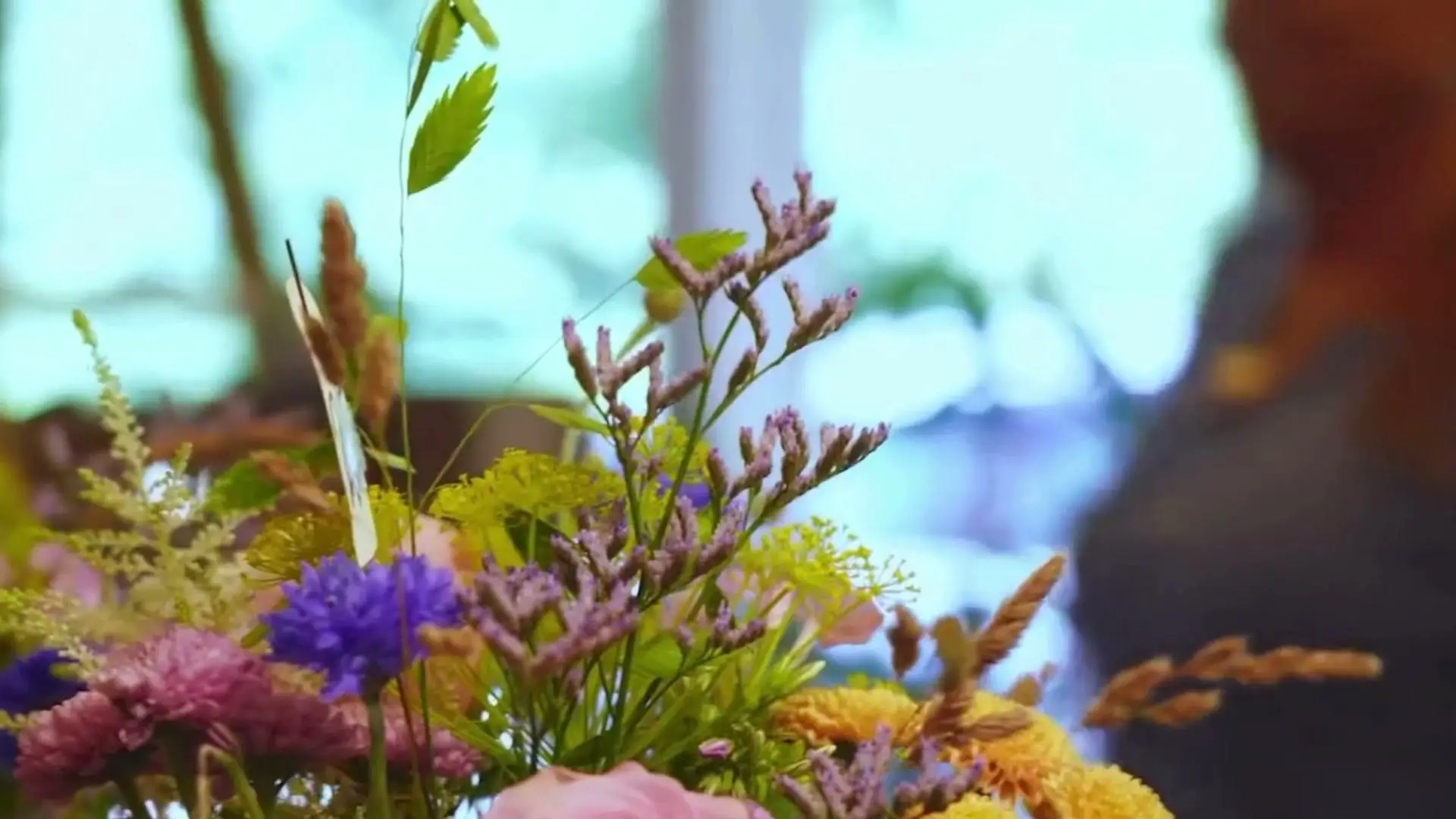 Buket med lilla, orange og rosa blomster i butikken